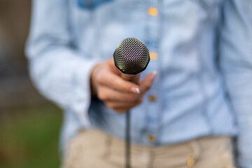 Reporter on the spot, holding microphone in hand