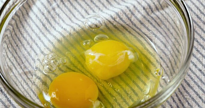 Cracking a White Organic Egg into a Bowl Ready to Whisk