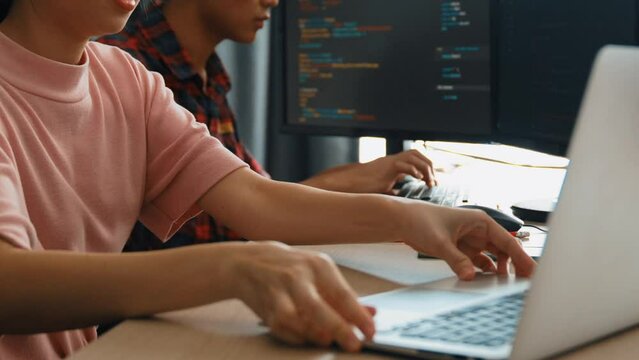 Slow motion back end software developer engineer for computer programming working together on debugging writing computing code, solving complex algorithms display on monitor in office. Burgeoning