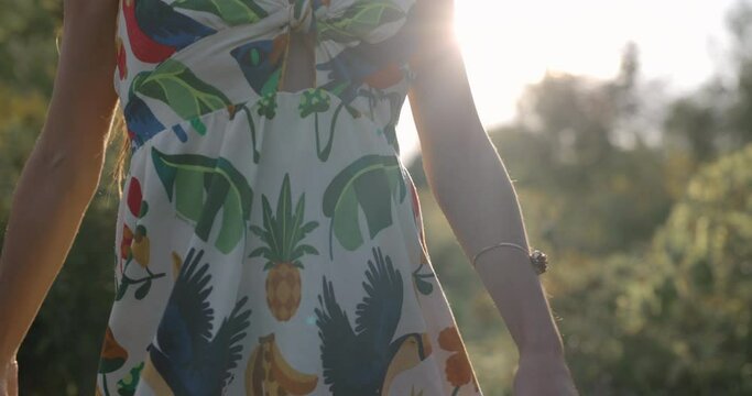 Young woman dances in feild of flowers at sunset - spiritual activity