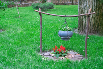 a cauldron for cooking on a decorative fire