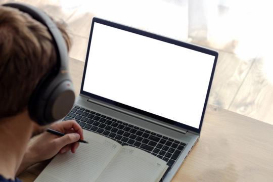 remote work space concept, man in wireless headphones makes notes