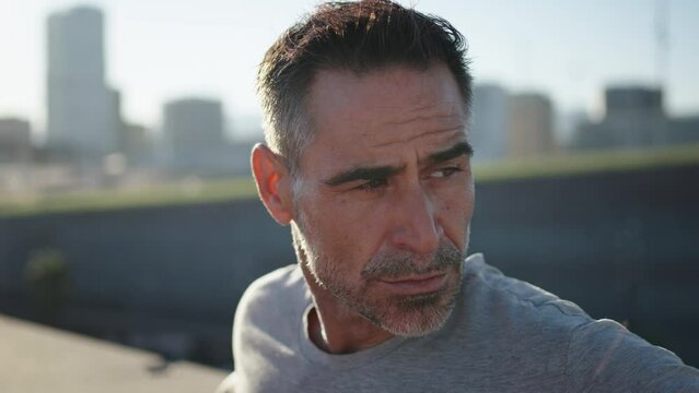 Close up mature Caucasian cardio man relaxing after running on urban. Portrait male runner resting and taking breath. Handsome adult athlete waiting to fitness training outdoor. Daily sports routine 