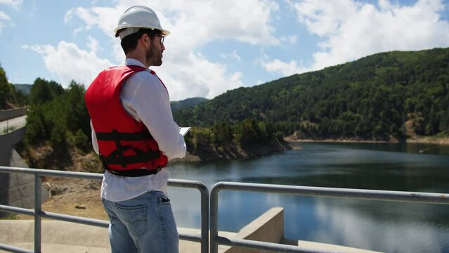 Engineer checks water flow of an artificial dam on the mountains