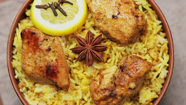 Chicken Biryani with Spices and Lemon in Clay Bowl, Popular Indian and Pakistani Food, Tilt Up Camera Movement