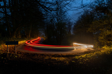 Curved road at night with light trails