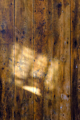 木漏れ日が差し込んだ木製壁の背景イメージ　古びた木製板を使用した板壁の背景