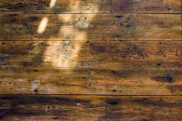 木漏れ日が差し込んだ木製壁の背景イメージ　古びた木製板を使用した板壁の背景
