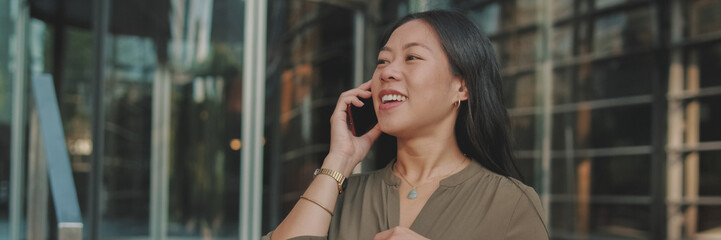 Young businesswoman talking on smartphone on business center background, Panorama