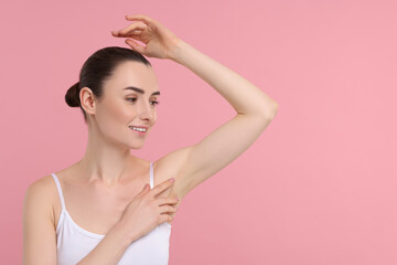 Beautiful woman showing armpit with smooth clean skin on pink background, space for text