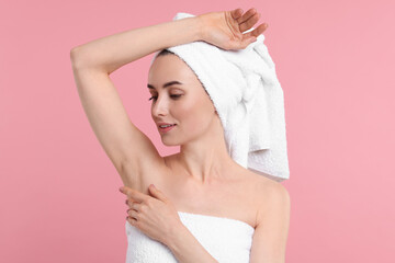 Beautiful woman showing armpit with smooth clean skin on pink background