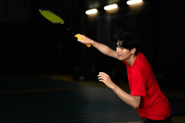 Badminton player in a receiving serve stance with a racket and feeling focused with determination....