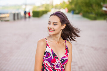 Portrait of a young beautiful brunette  girl in summer park