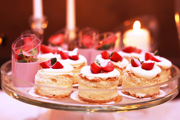Catering table with sliced chocolate cakes decorated with fresh raspberries and nuts.