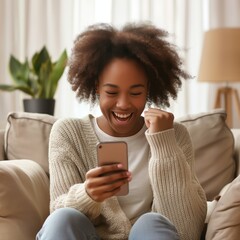 Exuberant young woman with afro hairstyle winning on smartphone at home.