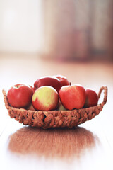 Wicker basket with fresh ripe red apples on wooden background. Harvesting. Autumn. September