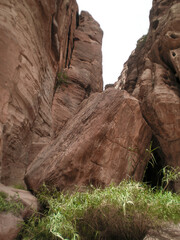 A fallen huge rock falls into the Al Siq gorge of the Petra historical reserve in the Wadi Musa city in Jordan