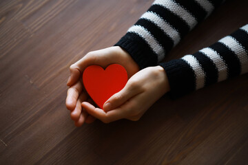 Hands of a woman holding and offering a heart shape. Love, health concept. Selective...