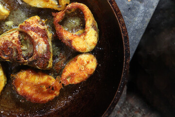 fried fish pieces on iron pan