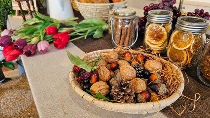 호두, 도토리, 솔방울 등이 있는 바구니와 튤립꽃 등의 인테리어 데코레이션