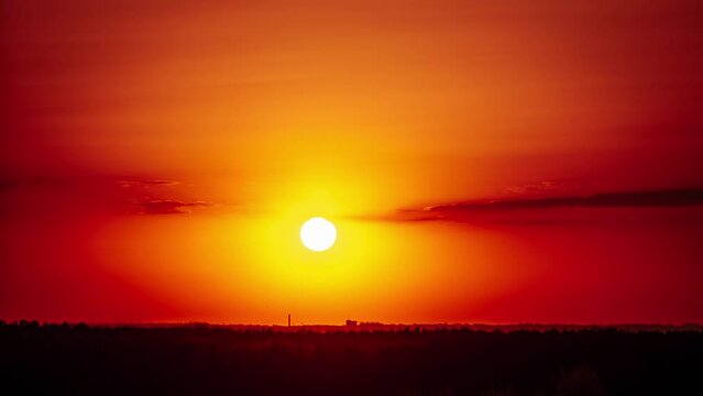 Sunset above the horizon in orange sky, timelapse. 4K. Bright sun setting down above the horizon. Epic, vibrant color. Time lapse. Sundown.