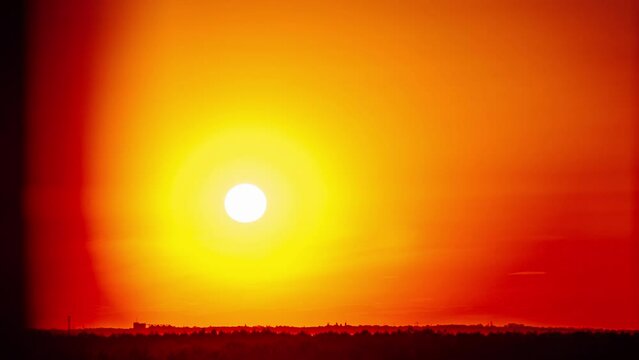 Sunset above the horizon in orange sky, timelapse. 4K. Bright sun setting down above the horizon. Epic, vibrant color. Time lapse. Sundown.