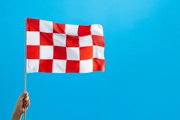 Foto op Canvas Human hand waving checkered flag on blue background © xy