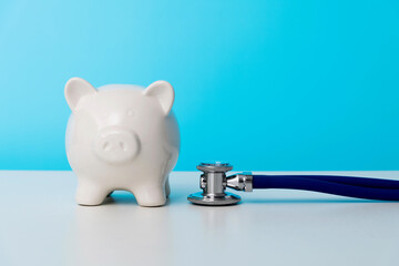 Piggy bank with stethoscope on the table