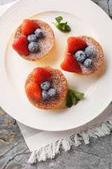 Fluffy Japanese Souffle Pancakes are like eating cottony clouds with fresh berries close-up on a plate on the table. Vertical top view from above