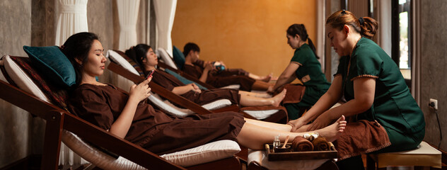 Professional Masseuse mature asian woman working service foot massage to customer in spa salon,...