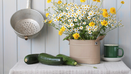 cute bouquet of daisies, rustic summer still life with flowers and zucchini on the table.