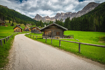 Wooden log huts and majestic mountains in San Nicolo valley