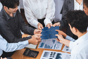 Corporate officer worker collaborate in office, connecting puzzle pieces with report paper on table...