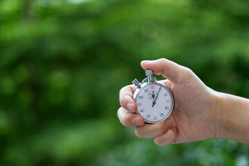 People hand holding stopwatch outdoors