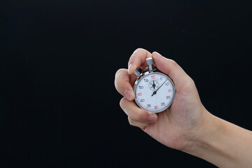 People hand holding stopwatch on black background