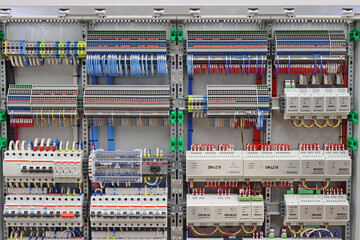An electric switchboard with modules for protection and control of electrical loads, mounted on din rails. - obrazy, fototapety, plakaty