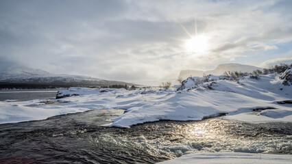 Fantastically beautiful winter landscape with sunshine, water and lots of snow in Swedish Lapland