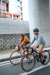 Fototapeta premium A couple is cycling in the city during summer time.