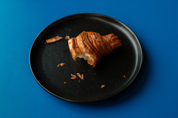 Delicious freshly baked croissant with butter on a plate