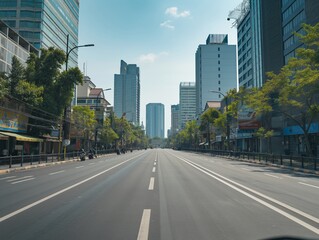 Empty urban street lined with modern buildings under a clear blue sky, showcasing a tranquil cityscape.