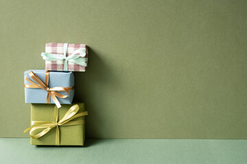 Stack of gift box on green table. khaki wall background. anniversary celebration concept