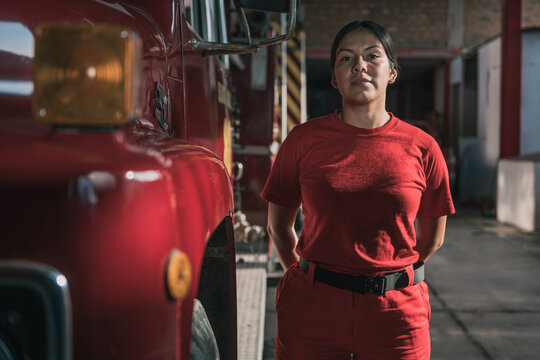 Portrait of smiling female firefighter standing at fire station