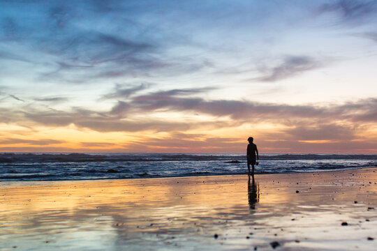 Young boy exploring at blue hour on the  beach.