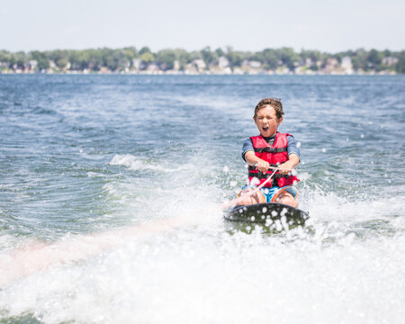 Young boy enjoys kneeboarding in Syracuse.