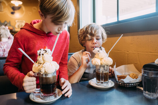 Kids drinking fun rootbeer floats with ice cream at restaurant