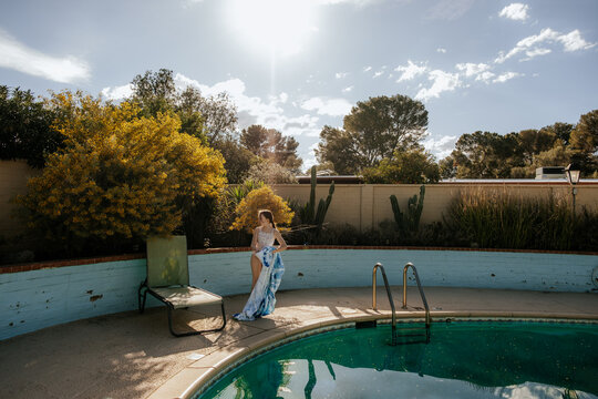 Girl standing on edge of pool on a sunny day