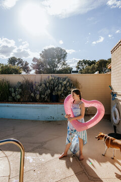 Young girl holding pool float on sunny day