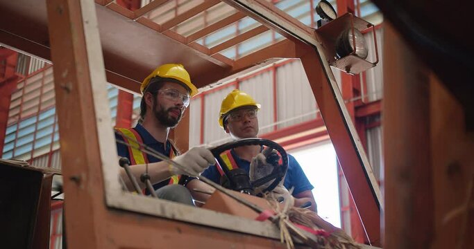 Construction workers engineers in yellow hard hats and safety vests are discussing operate a construction lift machinery within an industrial environment, focus on occupational safety and teamwork