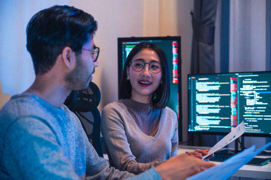 asian and Indian Developer  devops team discussion  about coding promgram with software computer at night in office