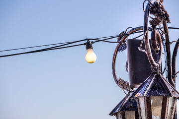 
Lanterns with a light bulb on a blue sky background - obrazy, fototapety, plakaty